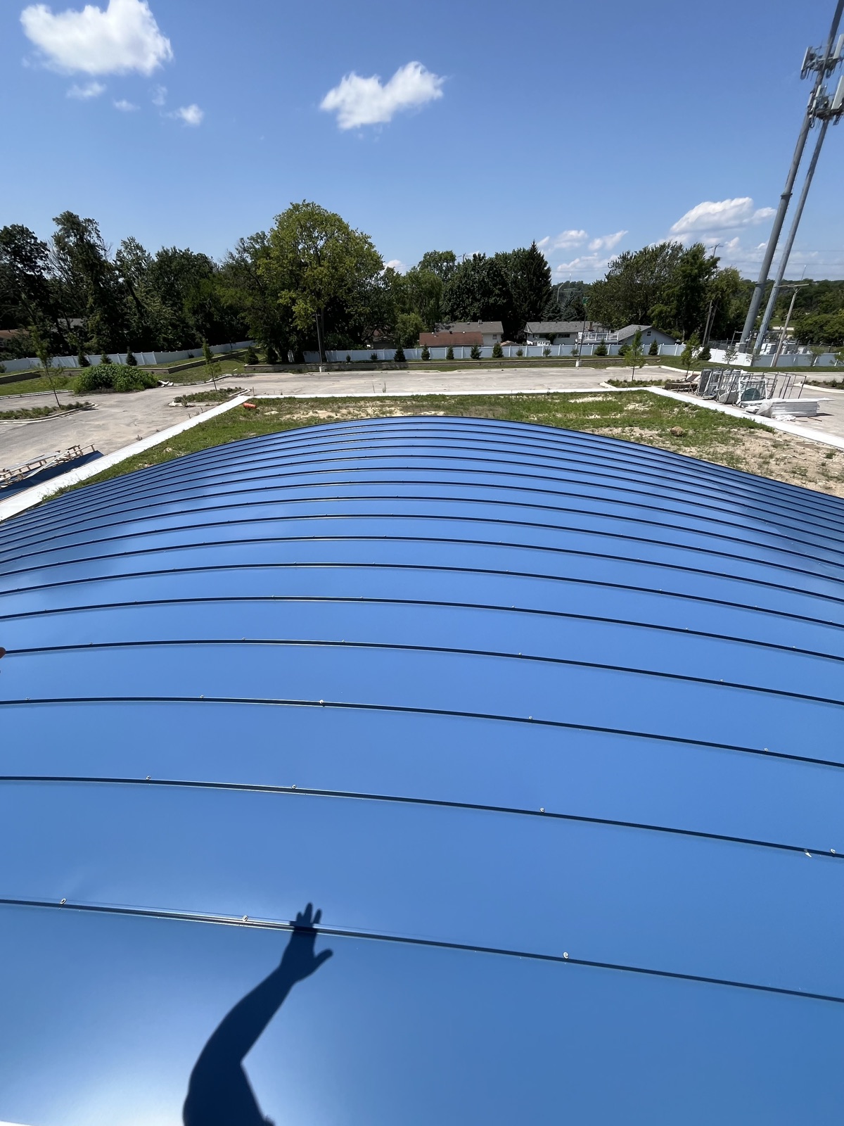 Curved standing seam metal roof against blue sky