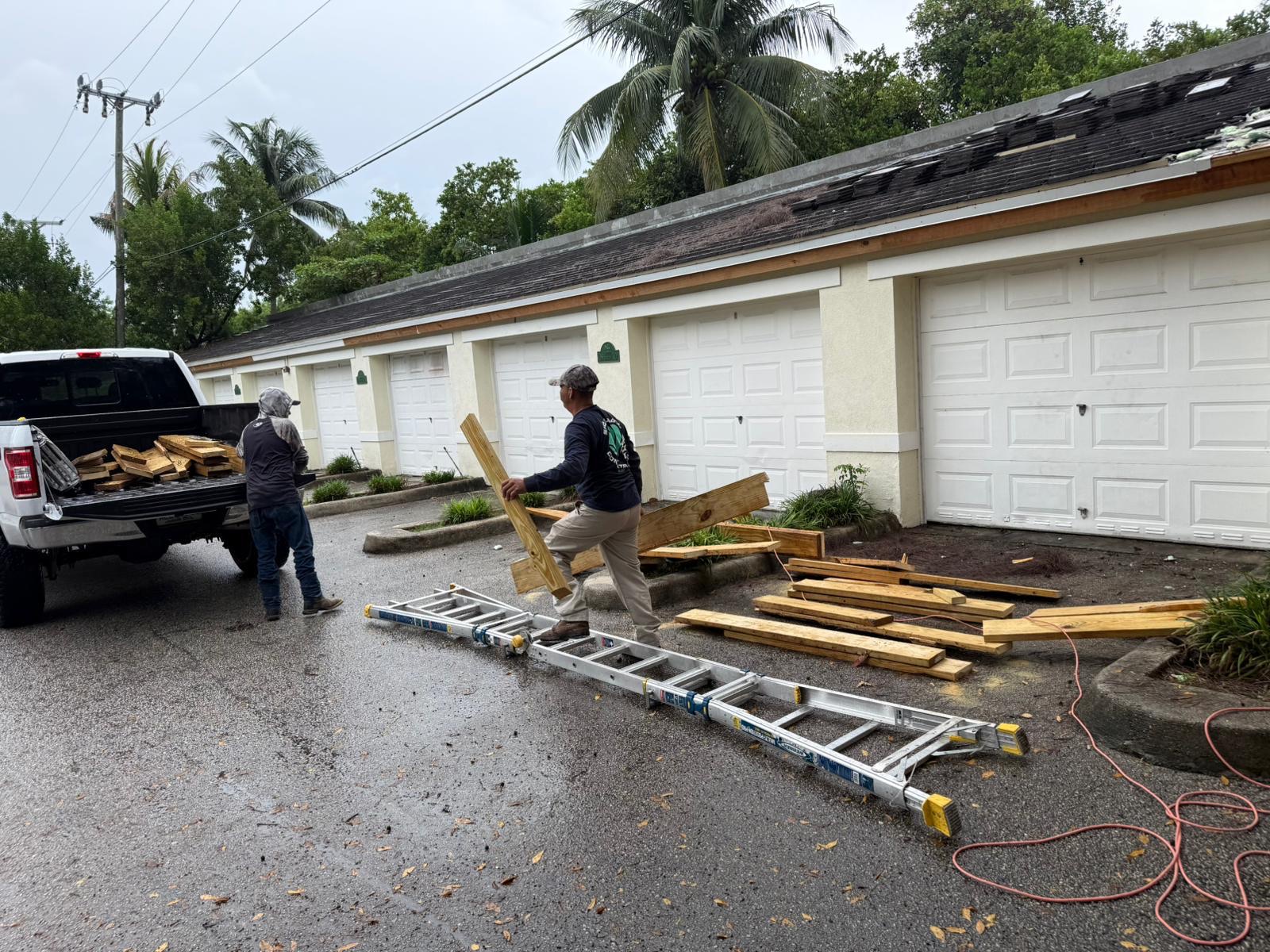 Roofing crew loading tear-off debris onto truck