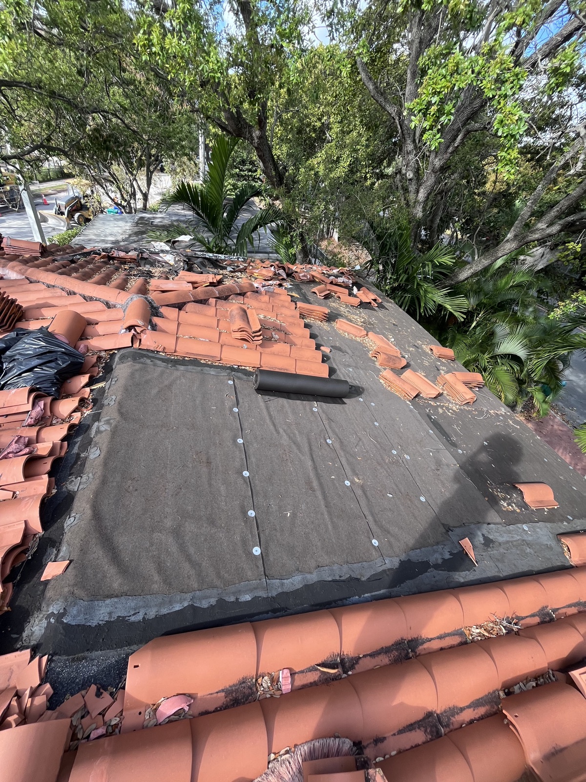 Close-up of clay tile roof tear-off exposing underlayment