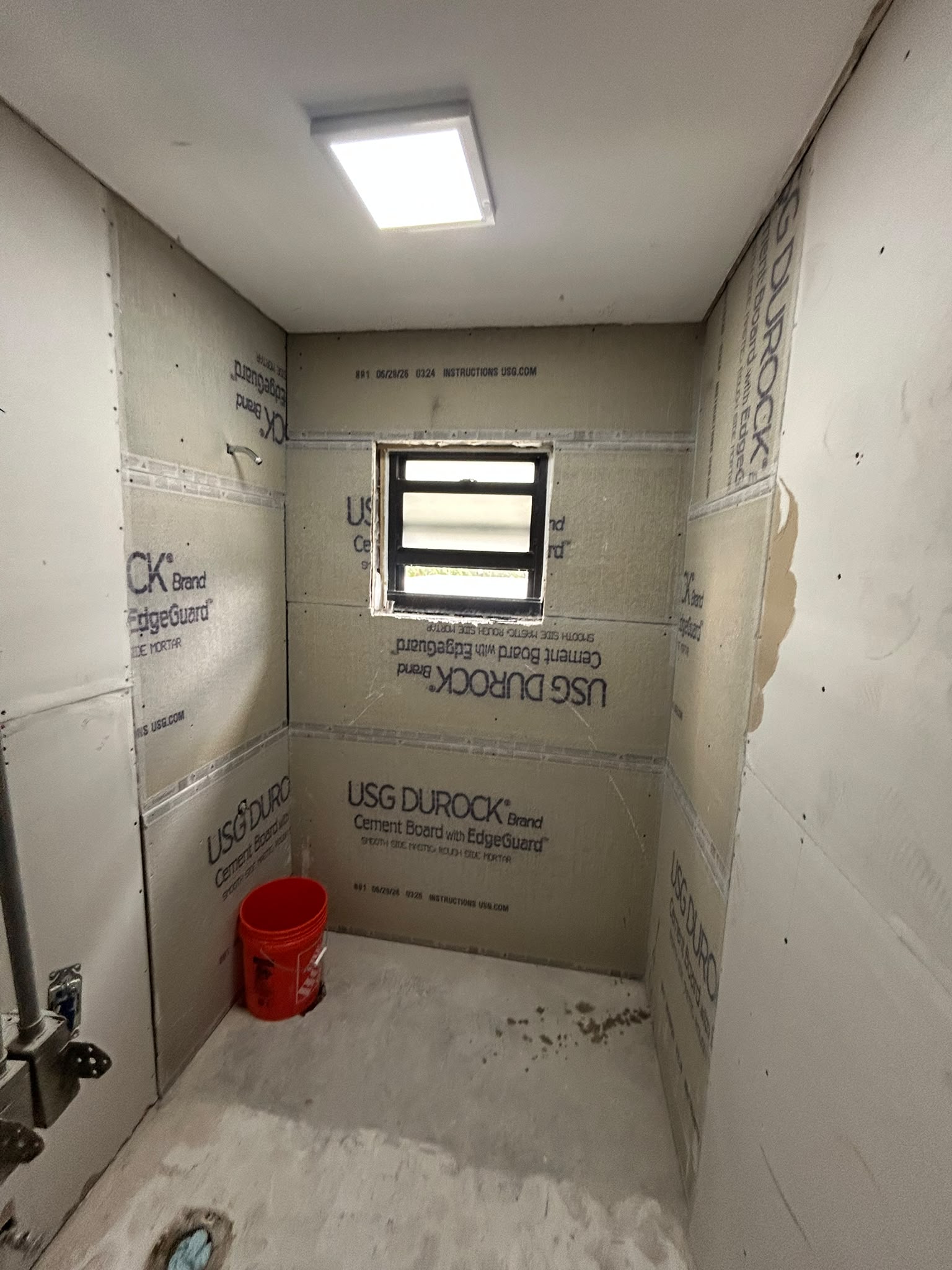 Bathroom shower area lined with cement board around window
