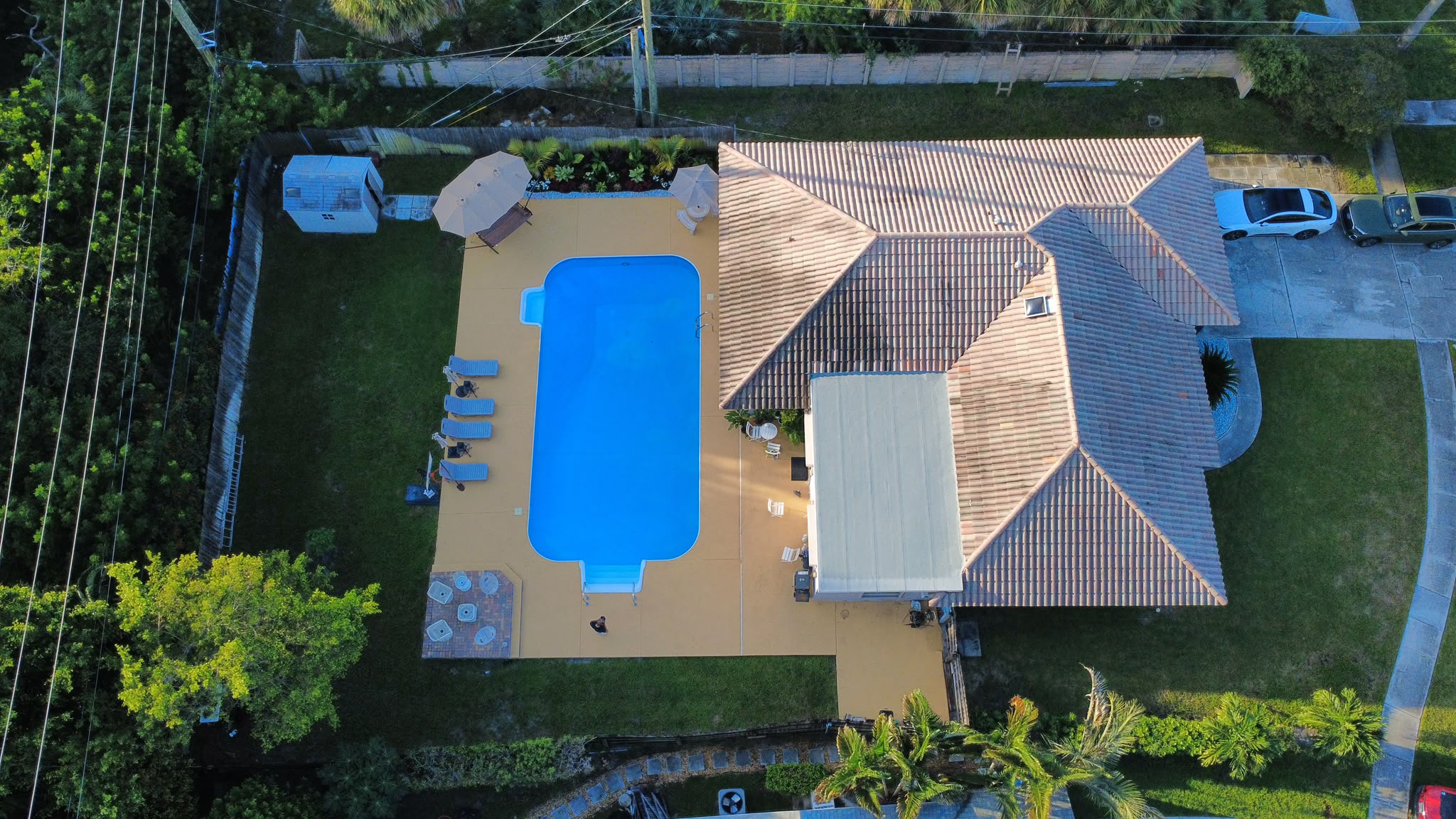 Aerial view of residence with tile roof and re-coated flat roof section