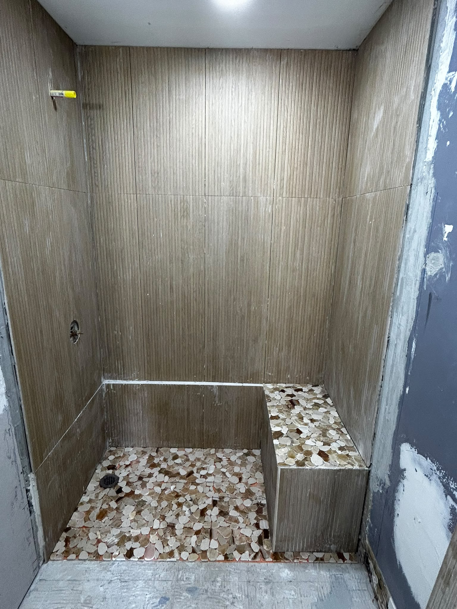 Finished pebble tile walk-in shower