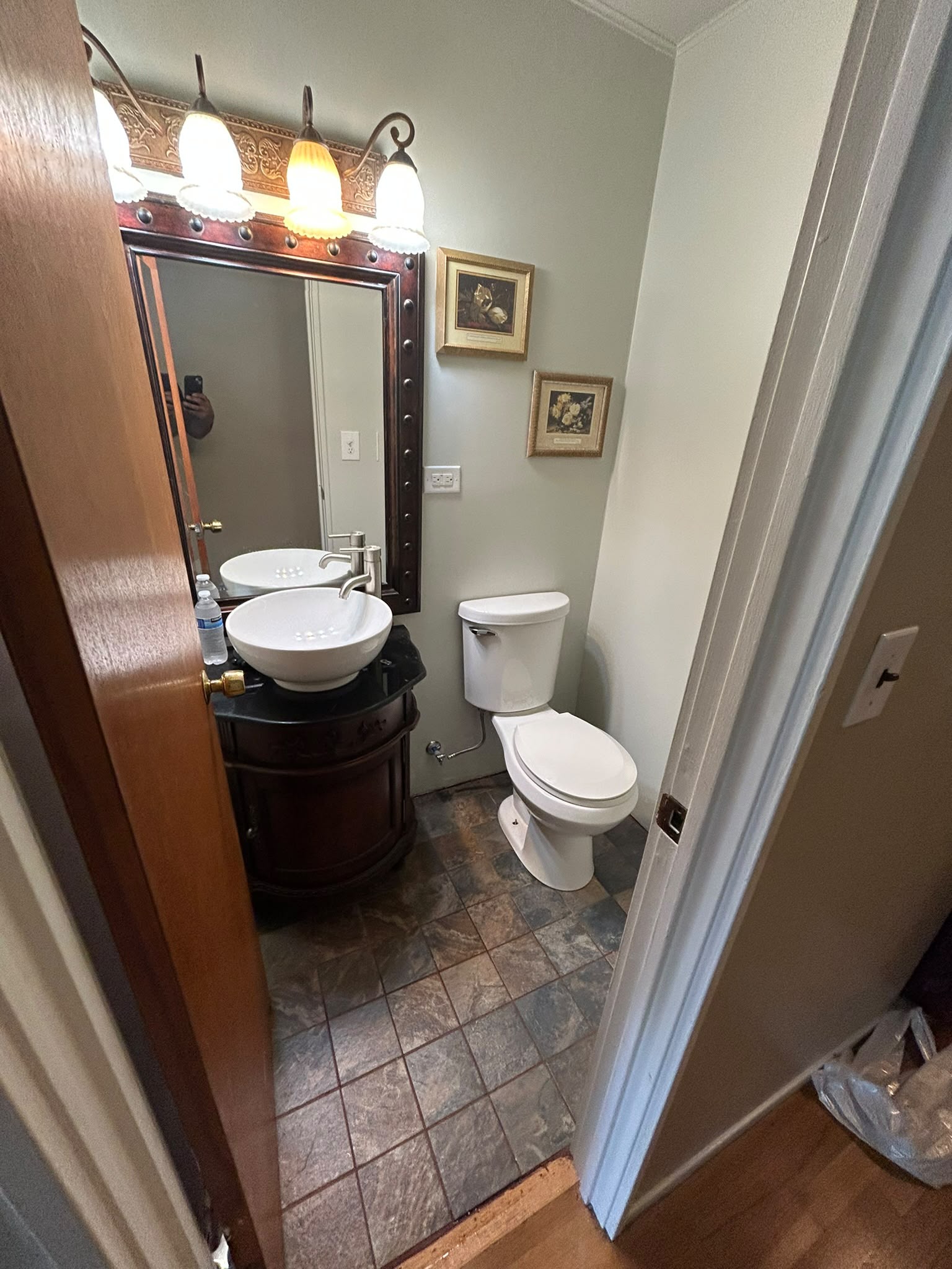 Powder room before remodel with slate floor and dated vanity