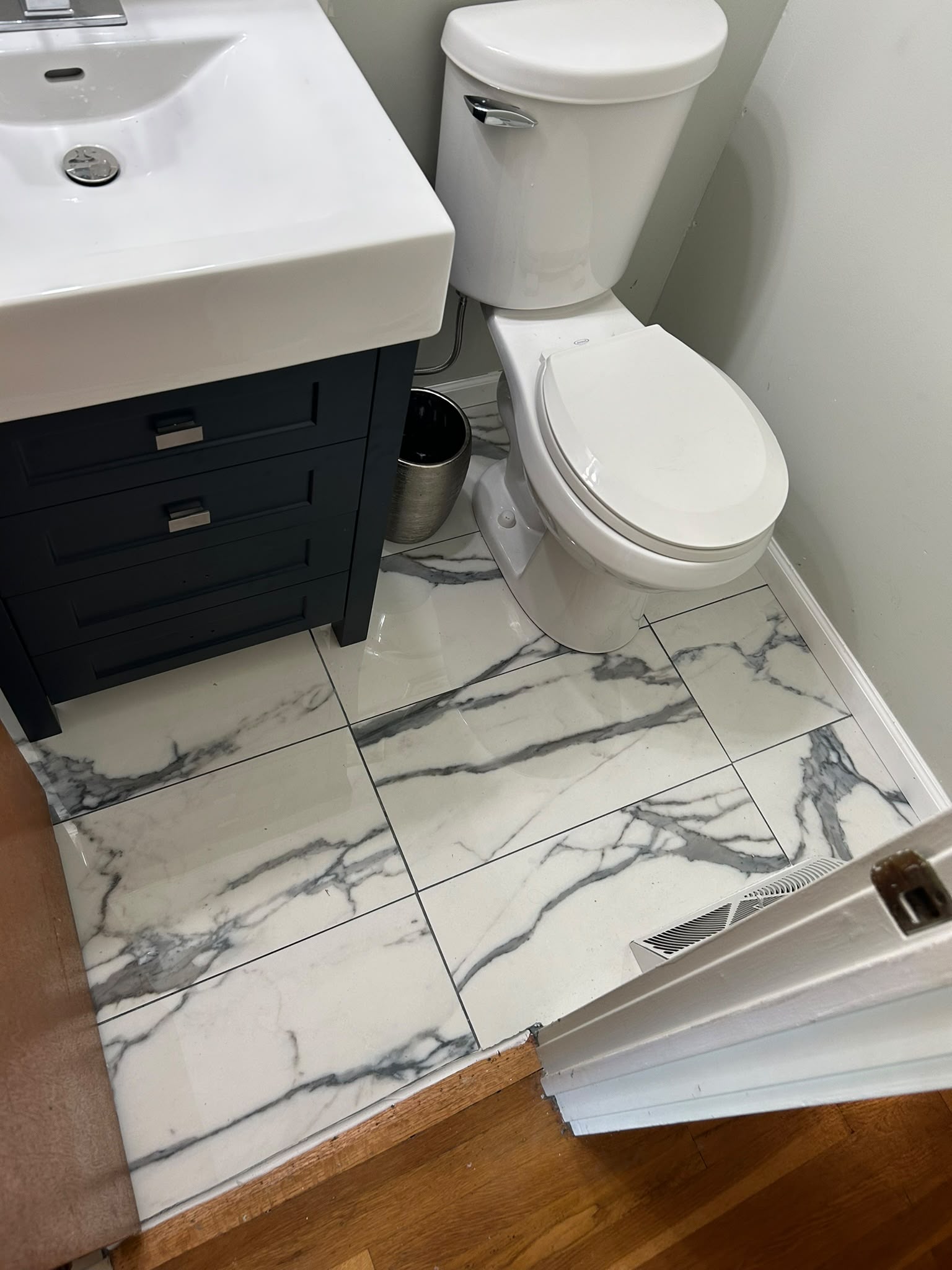 Finished powder room with marble-look floor tile and new vanity
