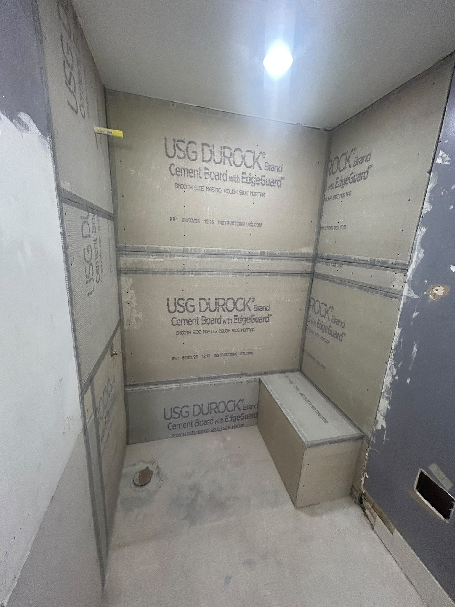 Shower framed with cement board and built-in bench before tile